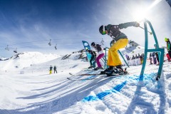 Skifahrer starten auf einer sonnigen Skipiste am Lift.