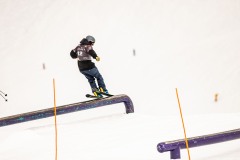 Skifahrer auf einer Rail im Snowpark.