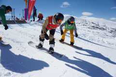 Snowboarder starten gemeinsam auf einer verschneiten Bergpiste.