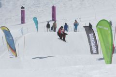 Snowboarder auf einer markierten Piste bei einem Wettkampf im Schnee.