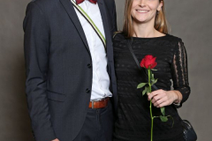 Mann im Anzug und Frau im schwarzen Kleid, sie hält eine rote Rose.