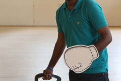 Mann in türkisfarbenem Poloshirt hält eine 5-kg-Kettlebell; oben links steht „#BEACTIVE“.