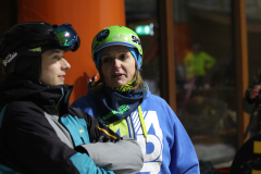 Zwei Personen mit Skihelm und Skibrille stehen nebeneinander, eine in schwarzer, eine in blauer Jacke.