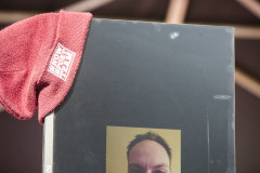 Rotes Stoffstück auf einem schwarzen Dell-Monitor vor unscharfem Hintergrund.